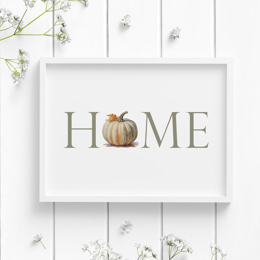 Single landscape print featuring the word HOME in capitals. The letter O has been replaced with an illustration of a pumpkin. Text is sage green and in a formal upper case serif font. The pumpkin is in complementary tones of green, cream and orange.