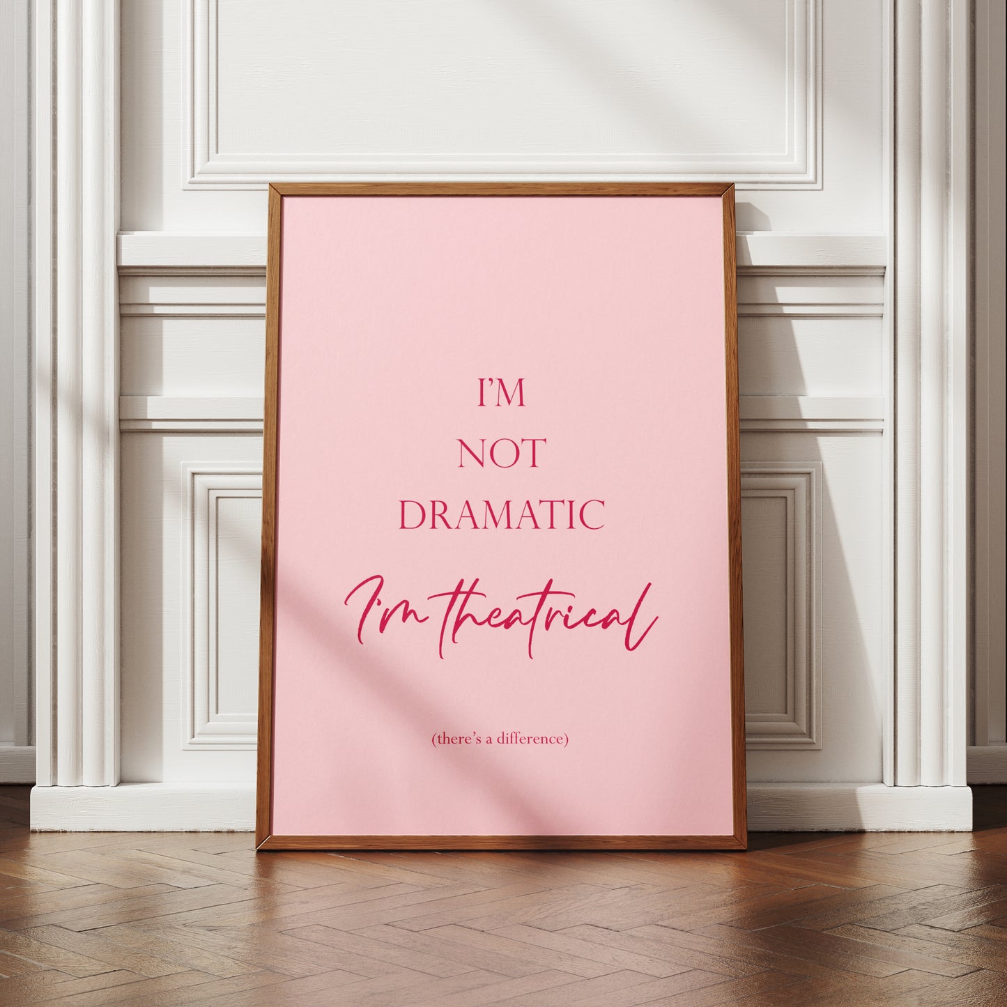 Single portrait typography print. Text reads: I'm not dramatic I'm theatrical (there's a difference). Text is dark pink on a pale pink background. The words I'm theatrical are positioned prominently in a modern script font. Remaining text is in a formal serif font.