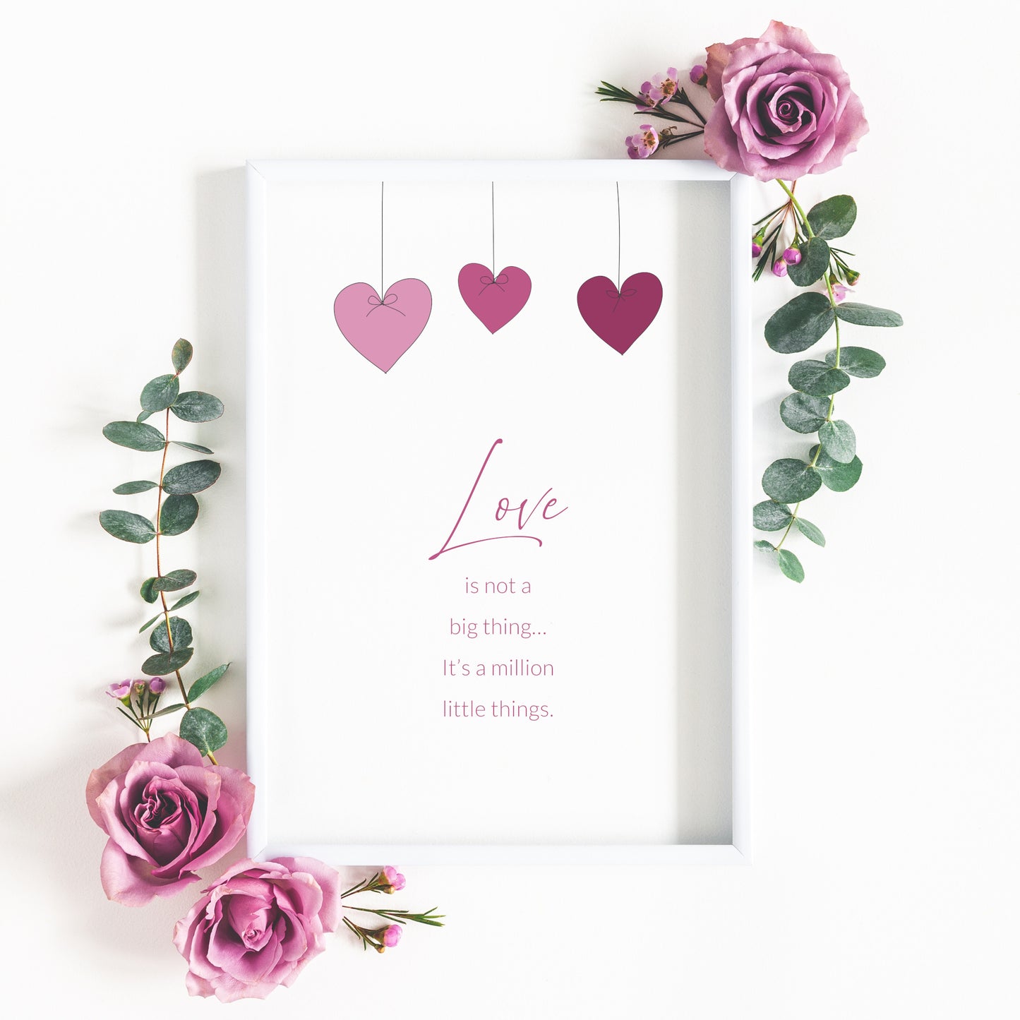 Portrait typography print, reading: Love is not a big thing, it's a million little things. The word love is placed prominently in a script font. Text is pink on a white background. Images of 3 heart-shaped baubles hang from the top.