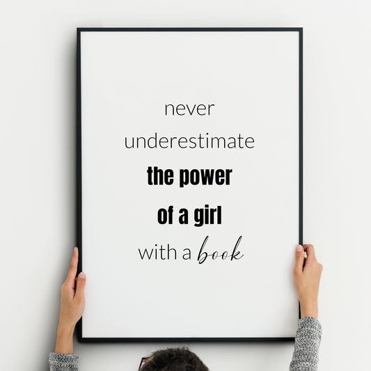 Single monochrome portrait typography print. Text reads: Never underestimate the power of a girl with a book. Text is in a  lower case sans serif font. &quot;The power of a girl&quot; is highlighted in bold and &quot;book&quot; is in a script font.