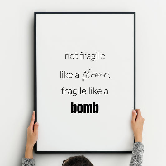 Single portrait typography print (black text on white). Text reads: Not fragile like a flower, fragile like a bomb -Ruth Bader Ginsburg. Text is in a lower case sans serif font, with the word flower in a script font, and the word bomb in bold.