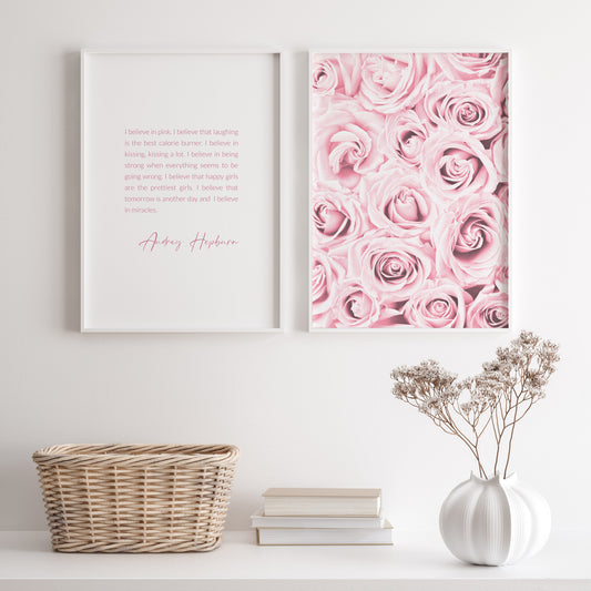 Set of 2 portrait prints. Print 1 features an inspirational quote from Audrey Hepburn, which begins "I believe in pink". Print 2 features a close-up photo of pink roses. The text is in a shade of pink complementary to the roses.