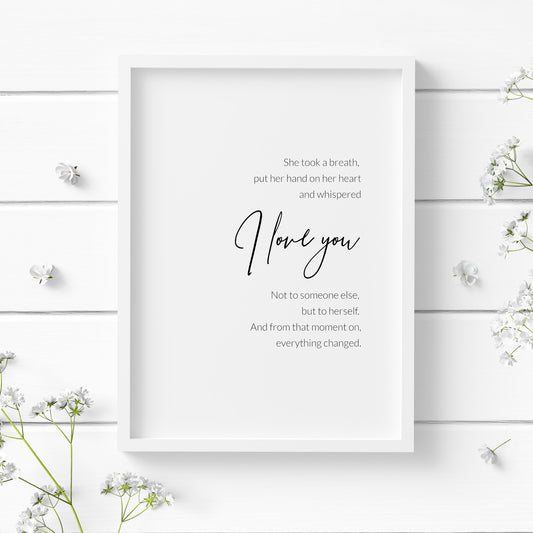 Single portrait typography print featuring the quote "She took a breath,  put her hand on her heart and whispered I love you. Not to someone else,  but to herself.  And from that moment on, everything changed.". The words "I love you" are positioned prominently in an elegant script font, with the remaining text in a crisp sans serif font. The full text is right-aligned and centred vertically. Text is black on a white background.