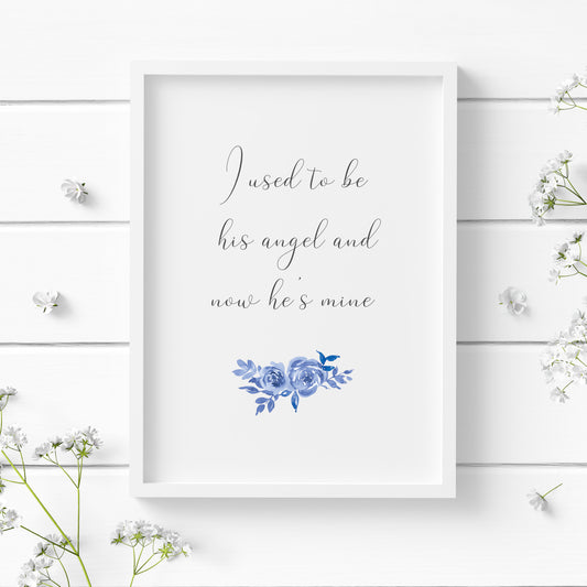 Single portrait typography print. Text reads: I used to be his angel and now he's mine. An elegant script font is used, with black text on a white background. Below the quote is a blue floral ornament.