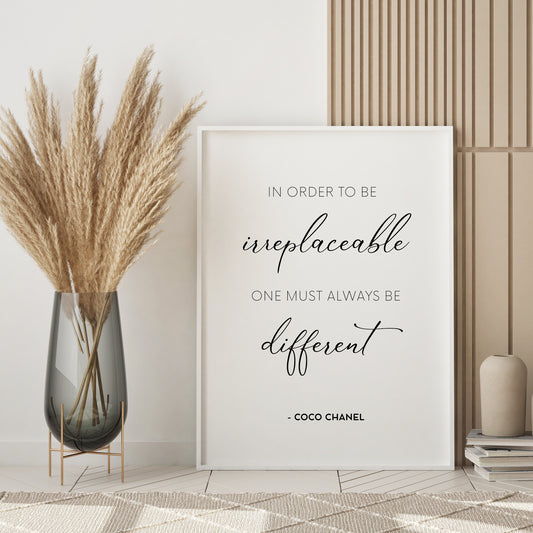 Single portrait typography print featuring a quote from Coco Chanel. Quote reads: In Order To Be Irreplaceable One Must Always Be Different - Coco Chanel. All text is black on a white background and in a crisp upper case sans serif font, with the exception of the words irreplaceable and different, which is displayed prominently in a script font.