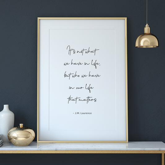 Single portrait typography print. Text in a script font reads:  It&#39;s not what we have in life, but who we have in our life that matters. This is followed by an attribution to J.M. Laurence in a simple sans serif font.