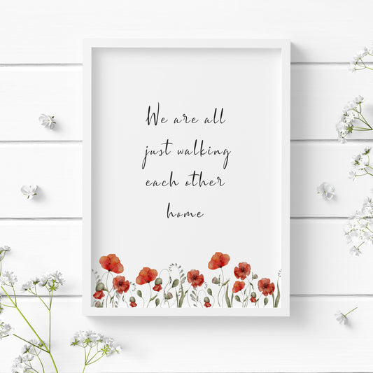 Single portrait typography print featuring a quote from Ram Dass. Text reads: We are all just walking each other home. Text is black on a white background and in a delicate script font. A watercolour illustration of poppies frames the lower edge of the print.