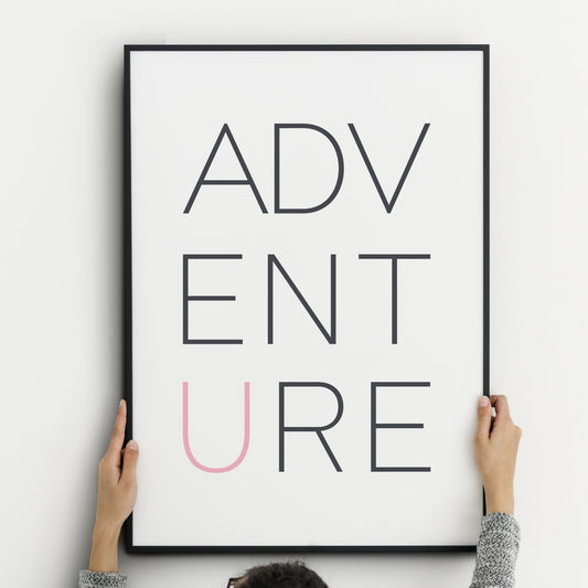 Single portrait typography print. Text reads: ADVENTURE, all in caps across three rows. Text is dark grey on a white background with the exception of the letter "u", which is in pink.