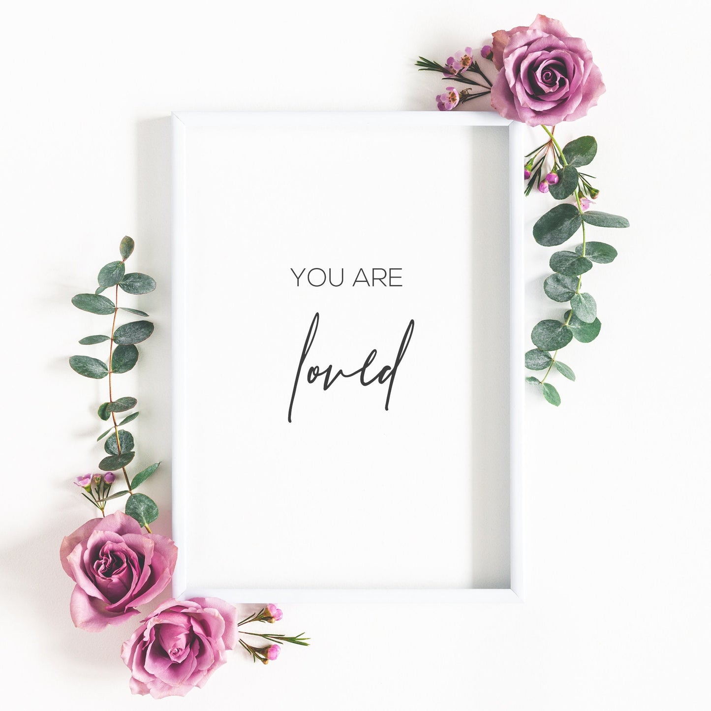 Single portrait typography print. Quote reads: You are loved. The word love is positioned prominently in an elegant script font, with the remaining text in a small, crisp, upper case sans serif font. Text is black on a white background. 