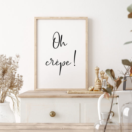 Single portrait typography print displayed in a kitchen setting. The text reads: Oh crêpe! The quote is displayed in a fun handwritten font that captures the essence of the quote.