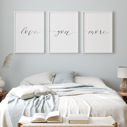 Set of 3 portrait typography prints. Text reads: love you more. The text is in an elegant script font with one word on each print. The leading and trailing letters of each reaches to the outer edges of the print. Text is black on a white background.