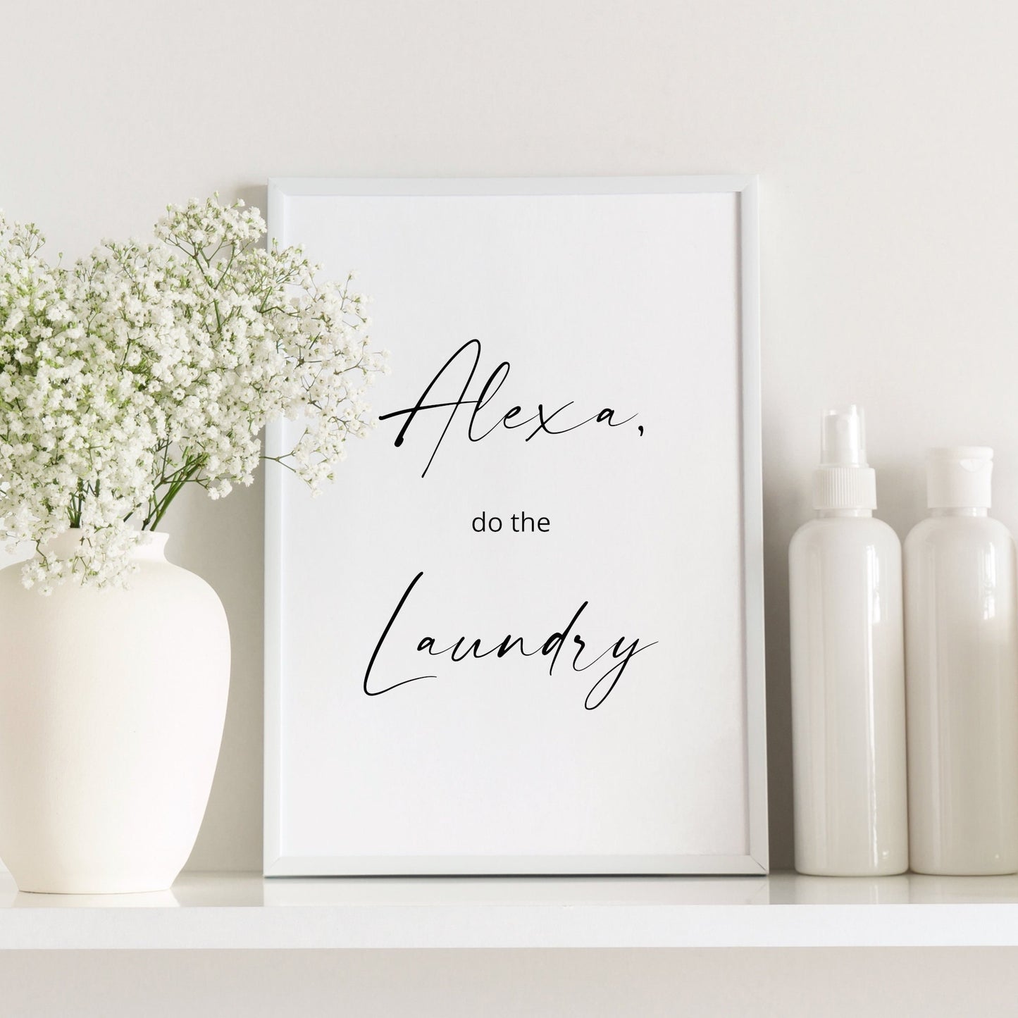 Single portrait typography print. Text reads: Alexa, do the laundry. The words Alexa and Laundry are positioned prominently in an elegant script font, with the other words in a small sans serif font. Text is black on a white background.