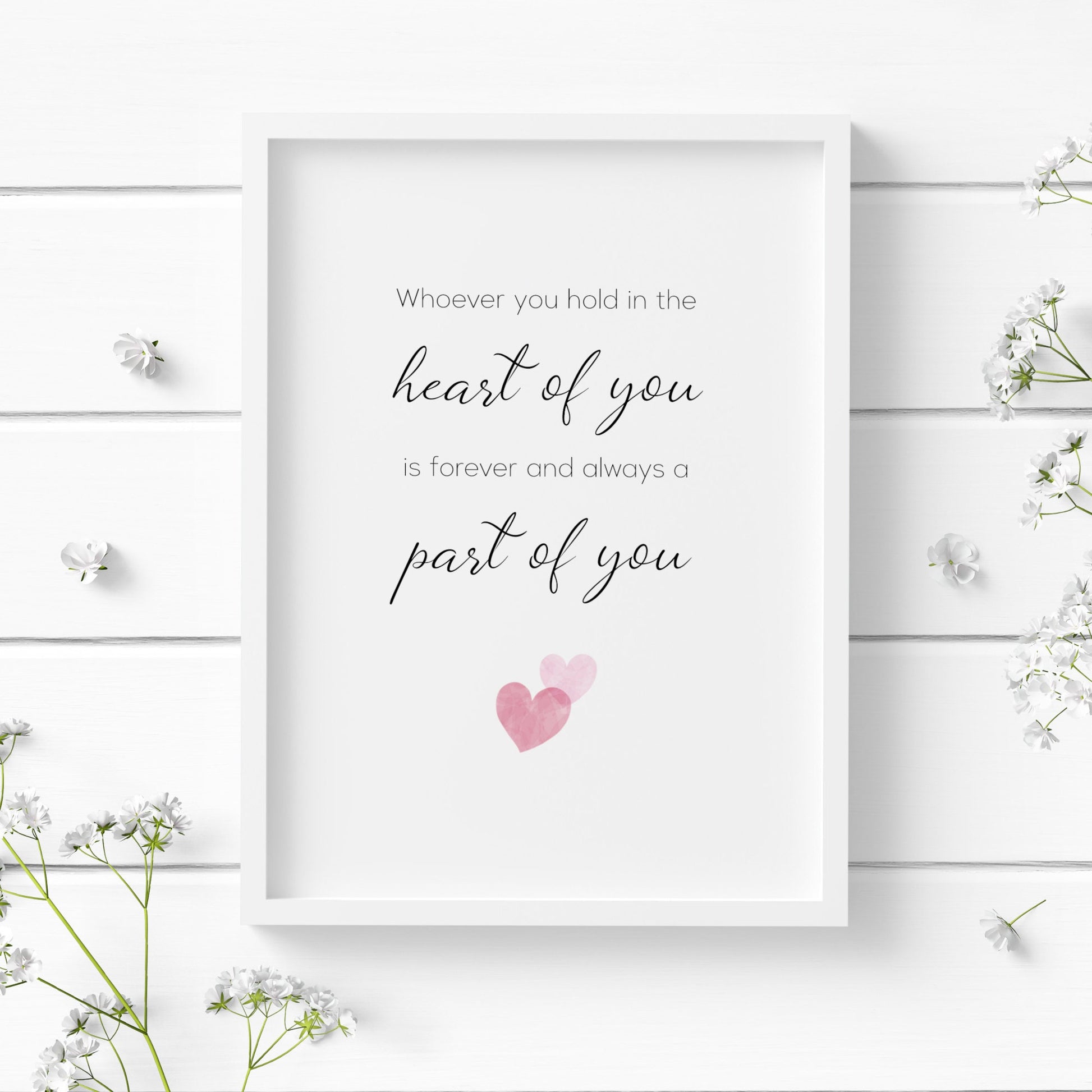 Single portrait print displayed in  a white frame. Text reads: Whoever you hold in the heart of you is forever and always a part of you. Two small overlapping pink hearts are displayed below the text.