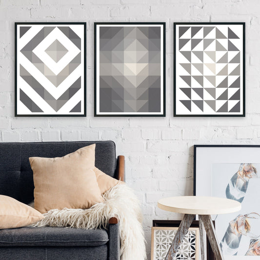 Set of 3 abstract geometric prints shown side by side on a gallery wall. Each print has a different pattern, all based on a fundamental triangle shape. All are in shades of grey.