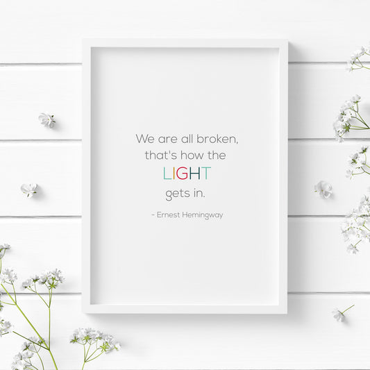 Single portrait typography print. Text reads "We are all broken, that's how the light gets in. - Ernest Hemingway". The word "light" is highlighted in multicolour and upper case. Remaining text is dark grey. Background is white. All text is in a modern sans serif font.