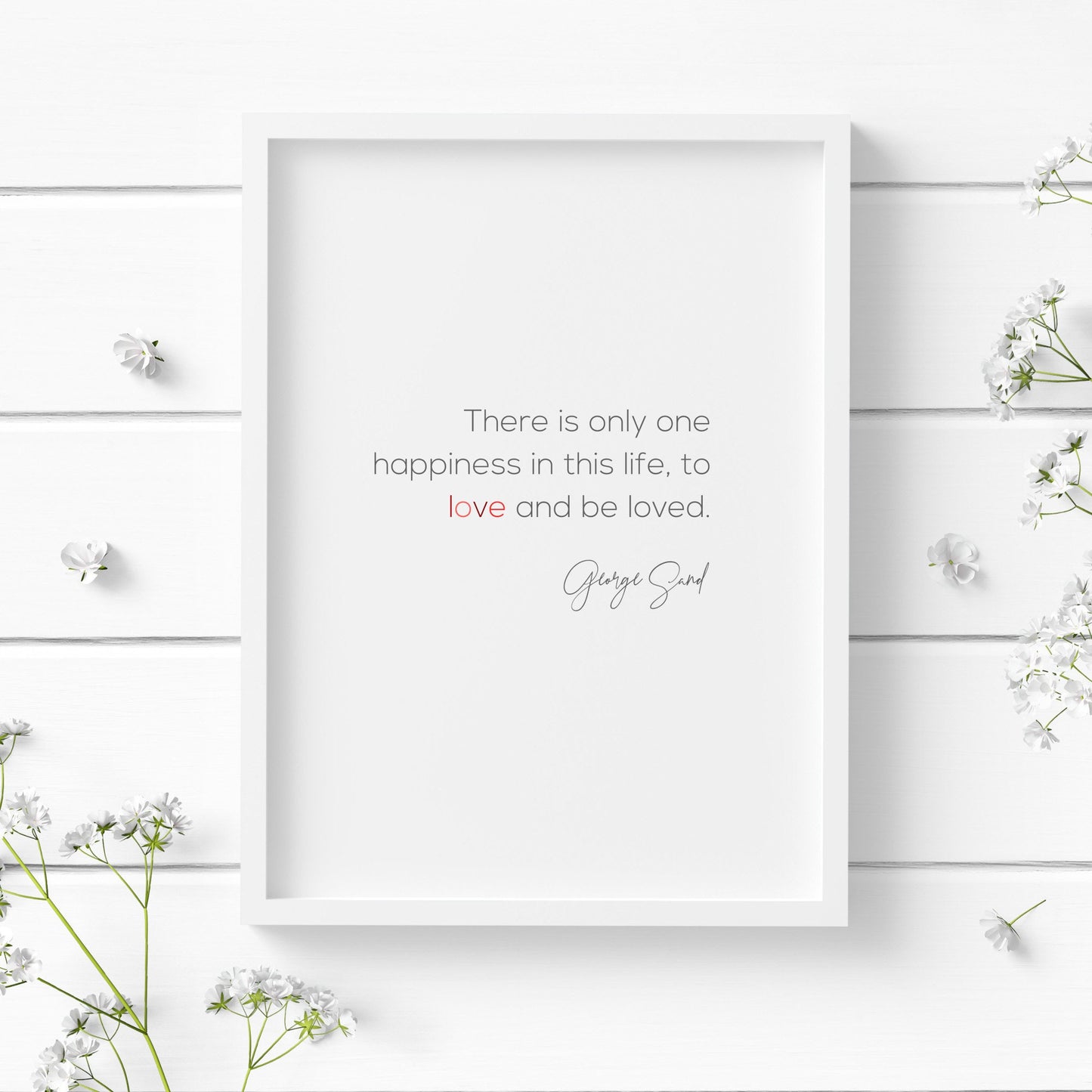 Romantic typography print. Text reads: There is only one happiness in this life, to love and be loved. George Sand. Body text is in a modern sans serif font, with the attribution in a striking script font. Text is black with the word love in shades of red.