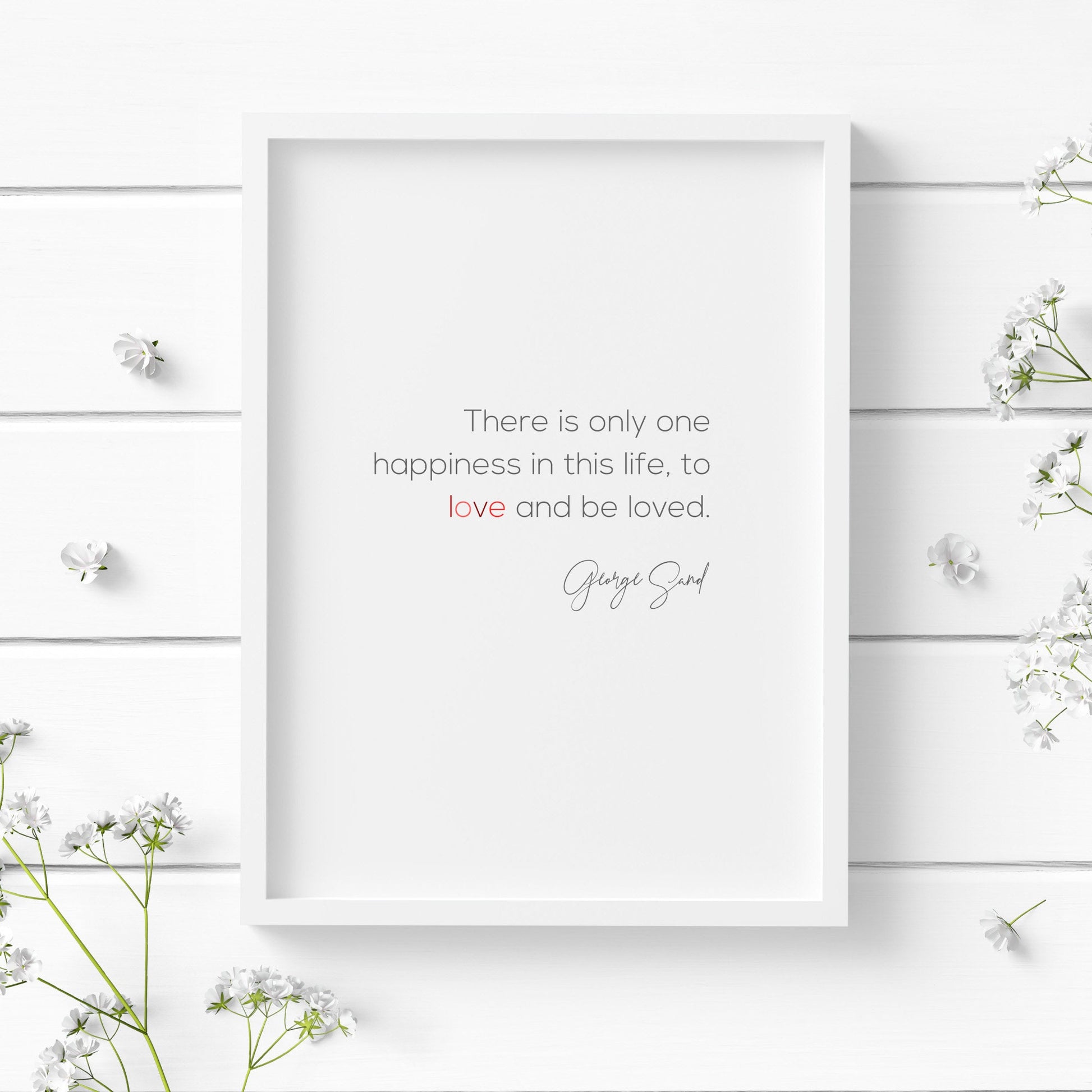 Romantic typography print. Text reads: There is only one happiness in this life, to love and be loved. George Sand. Body text is in a modern sans serif font, with the attribution in a striking script font. Text is black with the word love in shades of red.