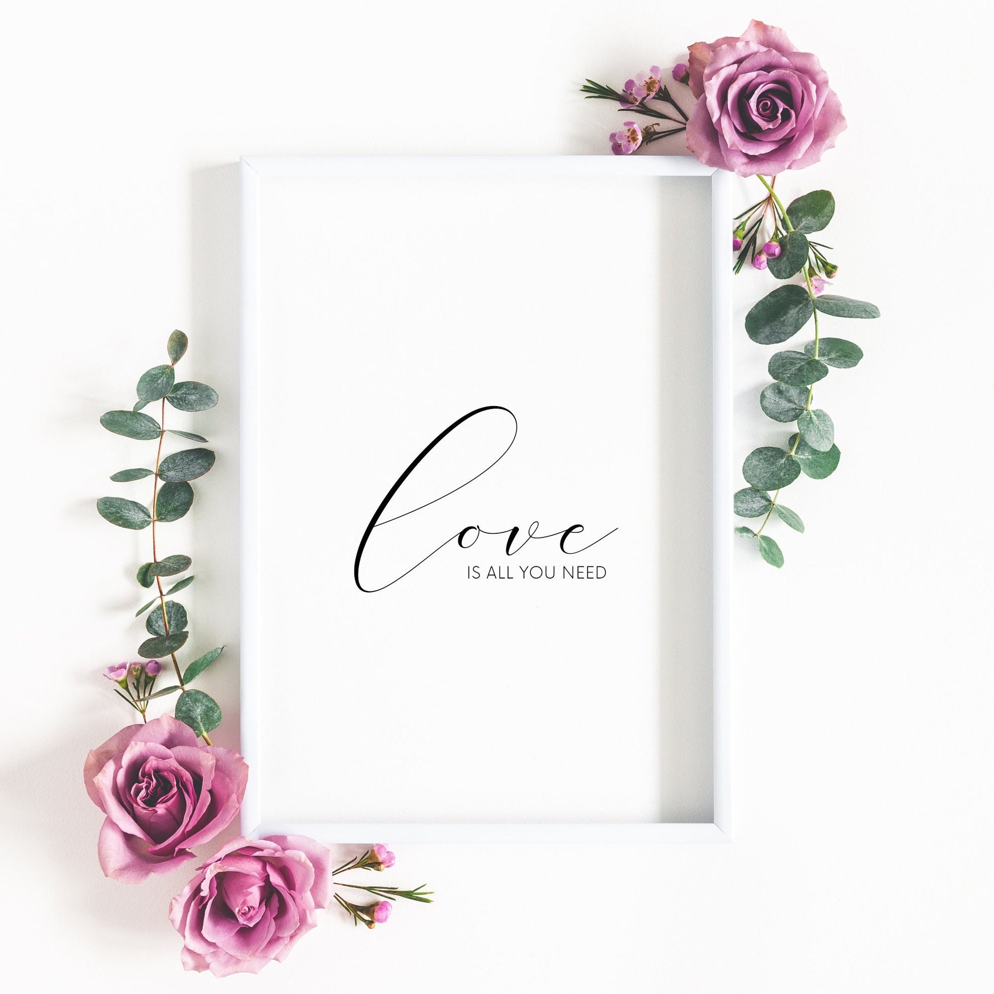 Single portrait typography print. Text reads: love is all you need. The word "love" is positioned prominently in an elegant script font. Text is black on a white background. It makes the perfect Valentine's Day gift.