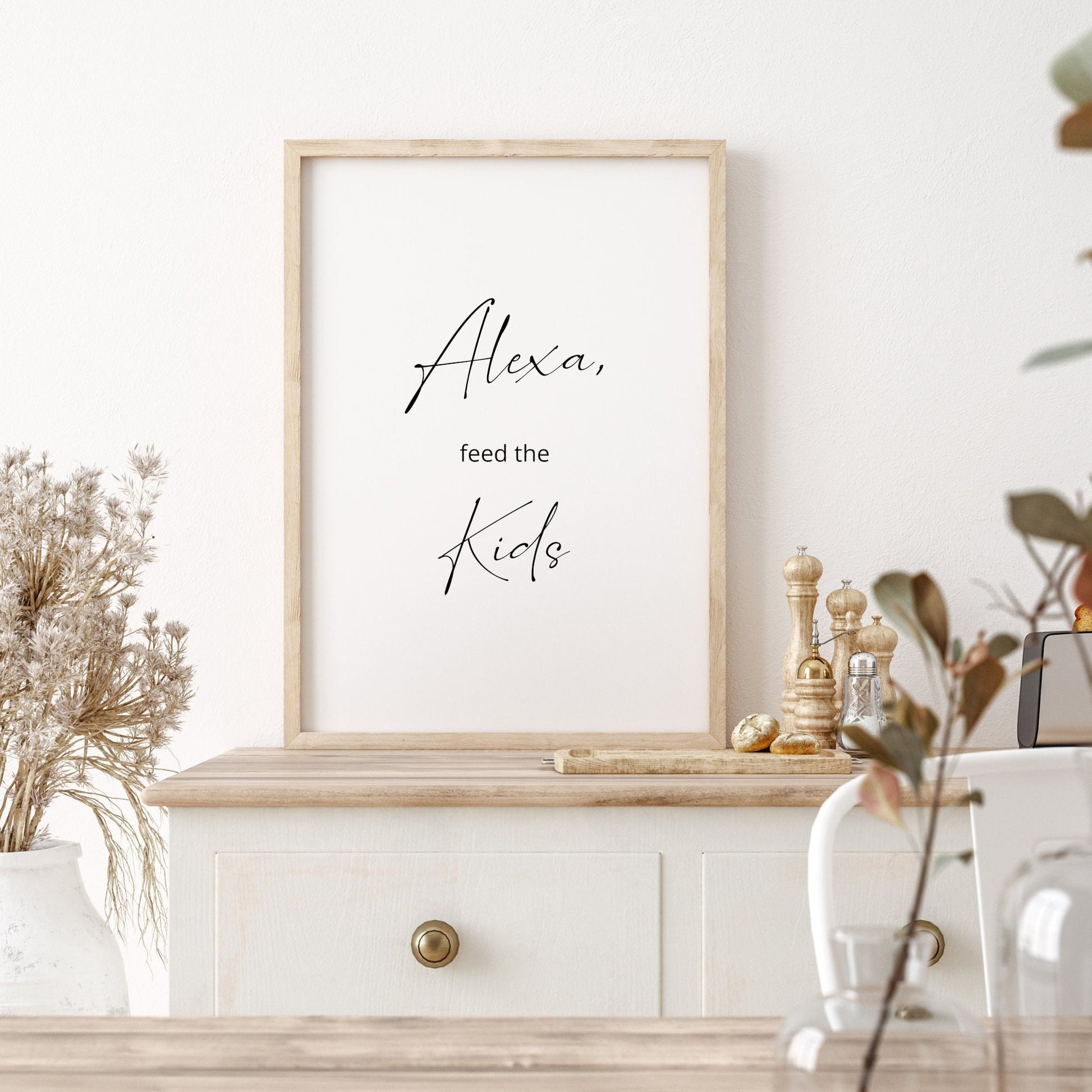 Fun portrait typography print for the kitchen. The black text on a white background reads &quot;Alexa, feed the kids&quot;. A contemporary script font is used for the words &quot;Alexa&quot; and &quot;Kids&quot;. Text is black on a white background.