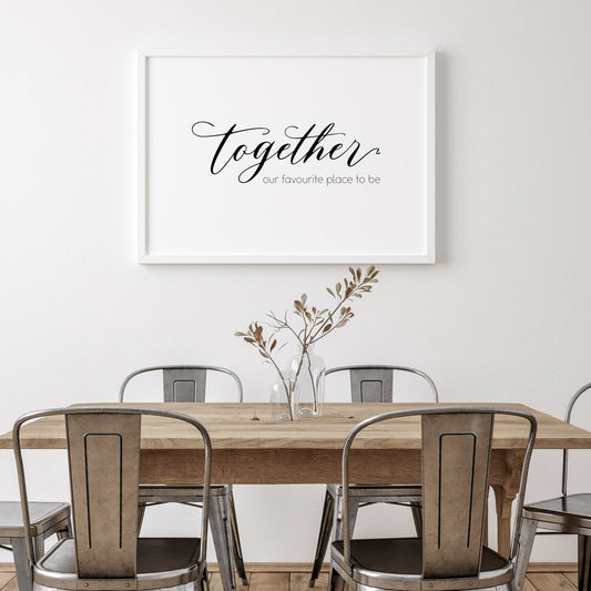 Single landscape typography print. Text reads: Together our favourite place to be. The word together is positioned prominently in a striking script font, with the remaining text in a small crisp sans serif font. Text is black on a white background.