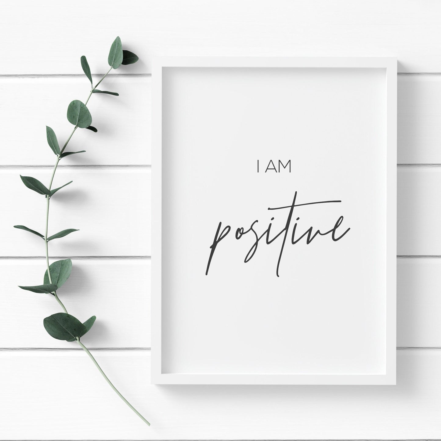 Single portrait typography print. Quote is a positive daily affirmation, which reads: I am positive. The word positive is displayed prominently in an elegant script font. Text is black on a white background.