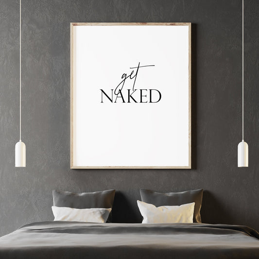 Single portrait typography print shown in a bedroom setting. Quote reads: get naked. The word "get" is in a stylish script font, contrasting with the upper case serif font used for the word "naked". Text is black on a white background.