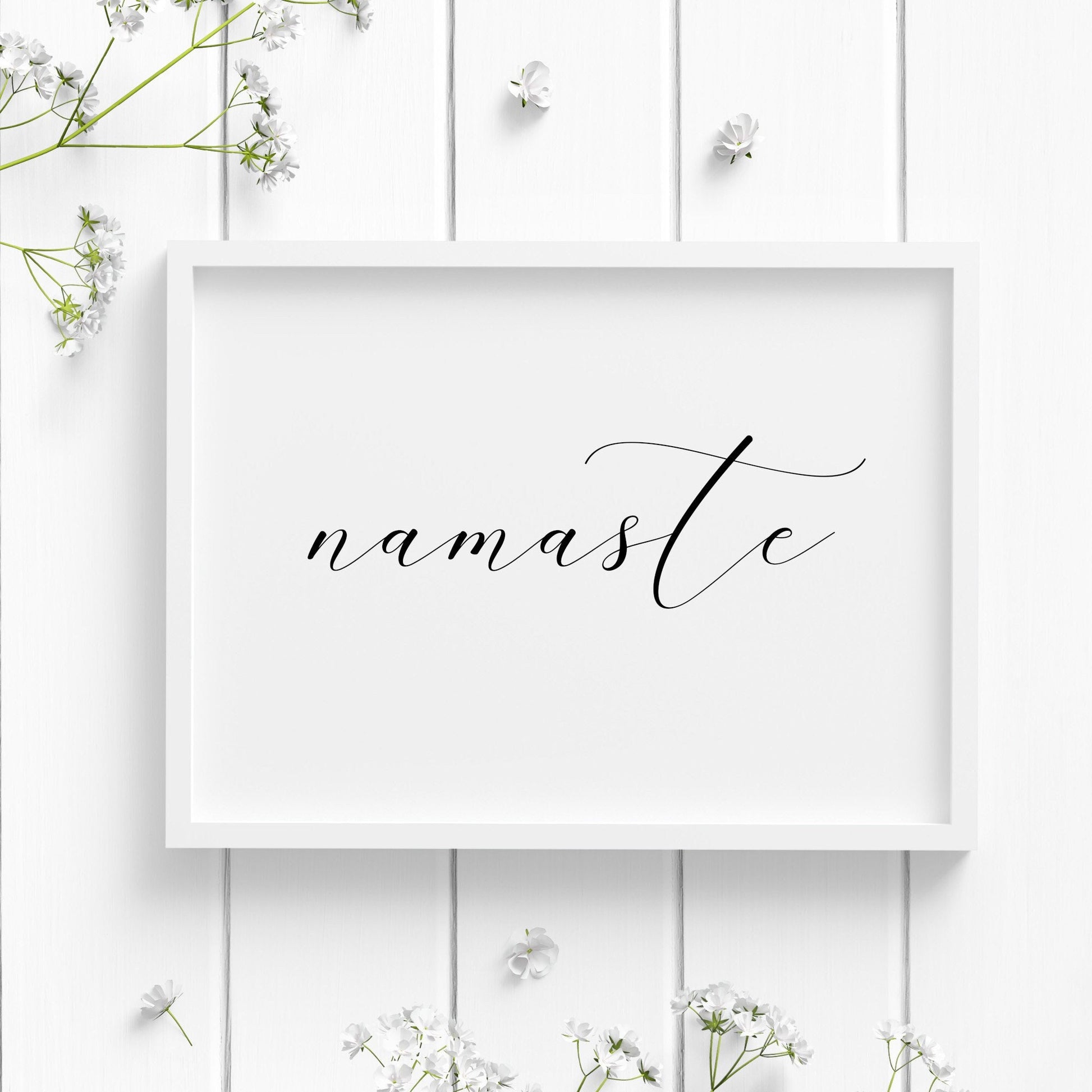 Single landscape typography print featuring the word namaste. An elegant script font is used and the word is all in lower case. Text is black on white background.